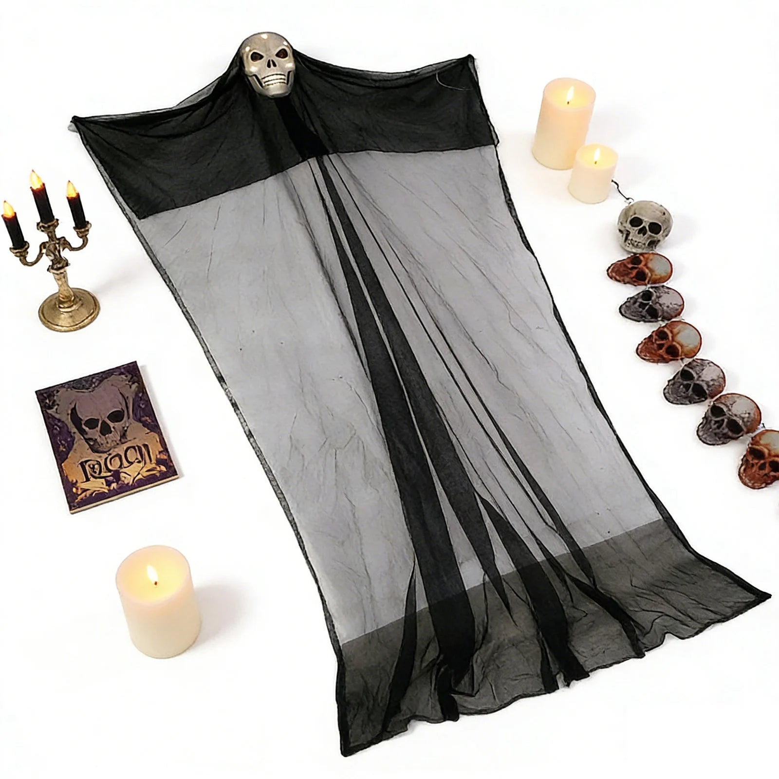 The 10-foot lighted hanging skeleton ghost is arranged flat with candles and Halloween props to show its full gauze shape.