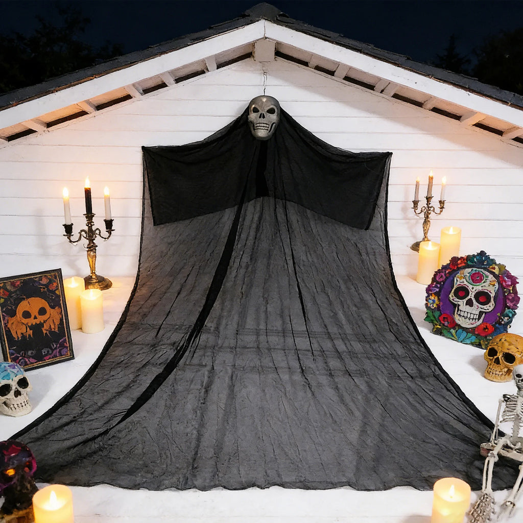 A themed setting presents large lighted skeleton ghost Halloween porch scene, with the skull head, wide black gauze and long hanging silhouette clearly visible.