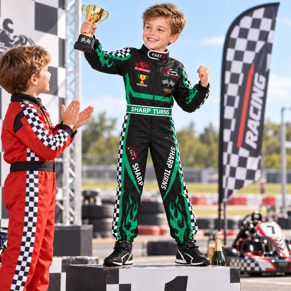 Child in a black green racing jumpsuit holds a separate trophy while another child wears a different red costume.