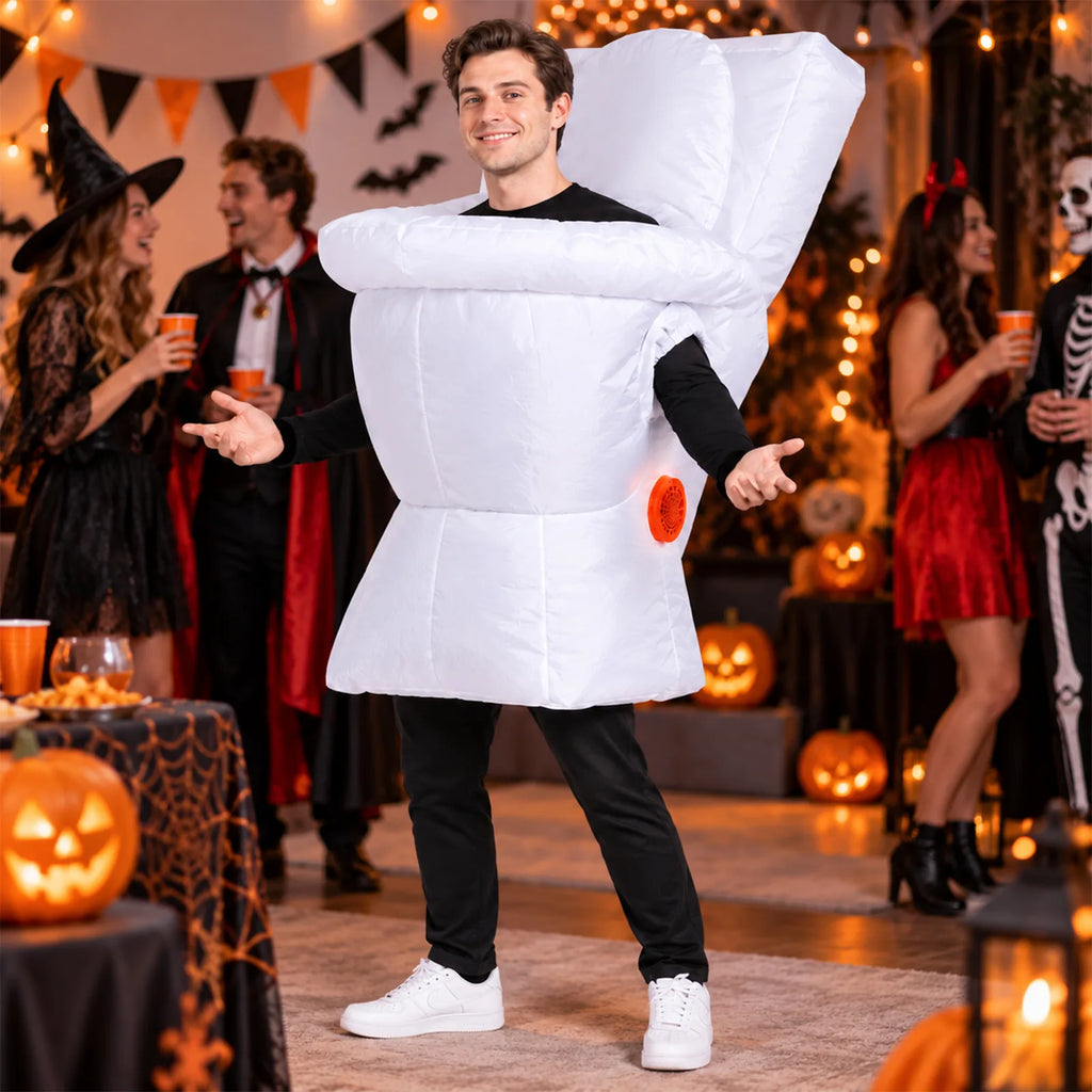 Adult wearing an inflatable toilet costume stands beside other guests at a Halloween party with pumpkins and hanging decorations.