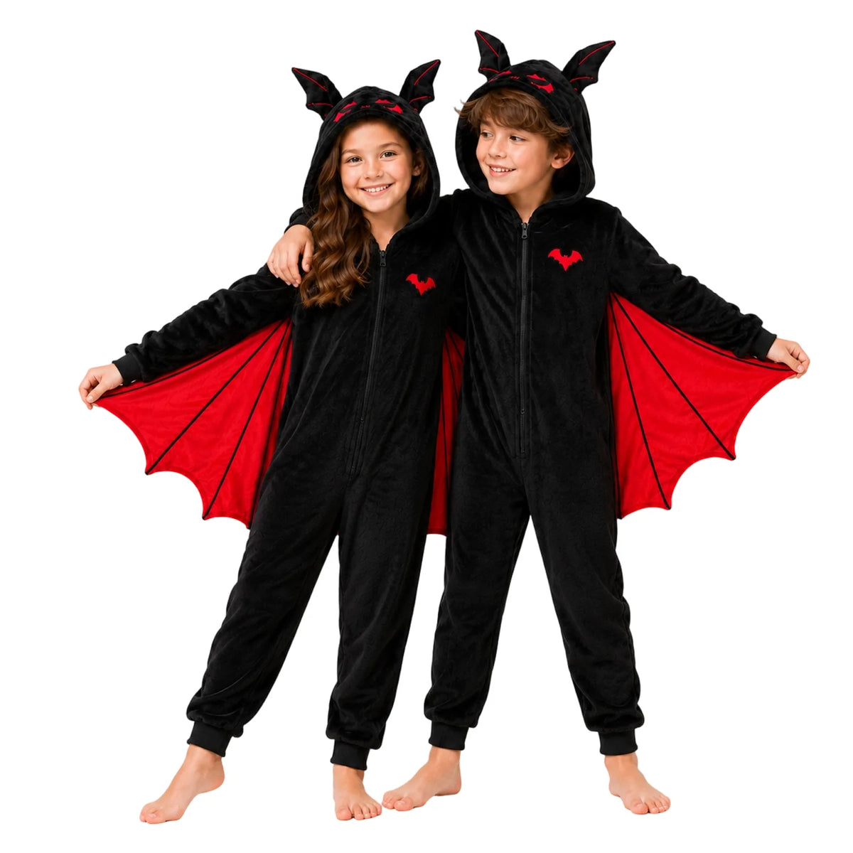 Two children model black bat onesies together, showing red and purple wing panels.