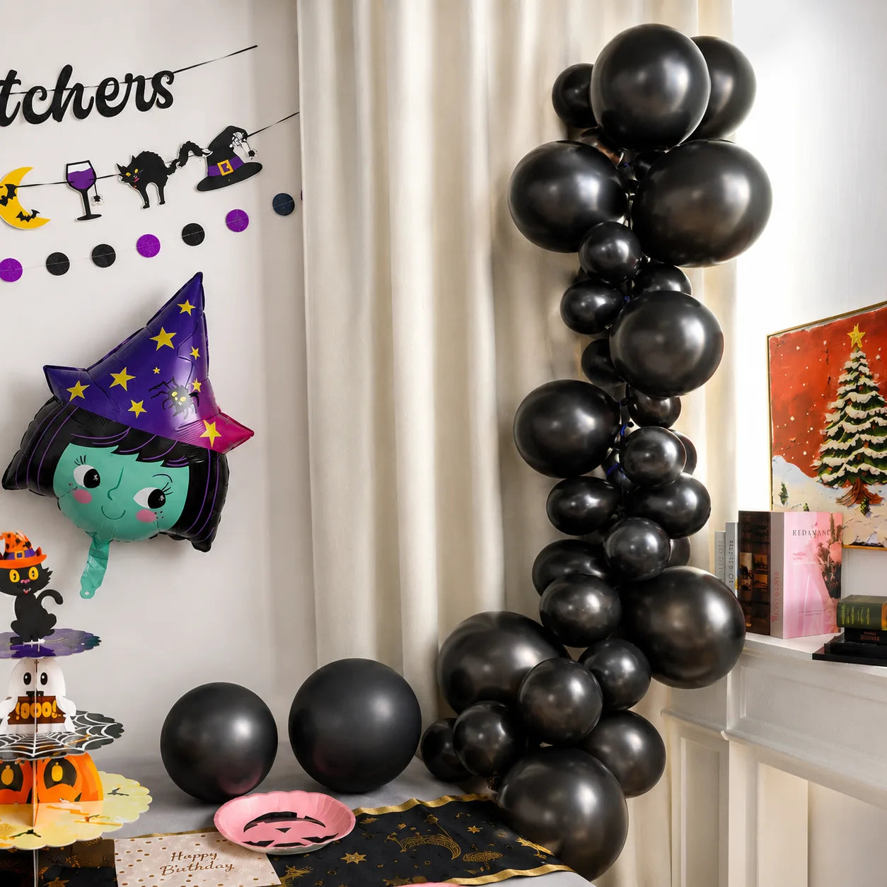 Black balloon arch for Halloween birthday party with witch foil balloon, table runner, pink pumpkin plate and little witch decorations