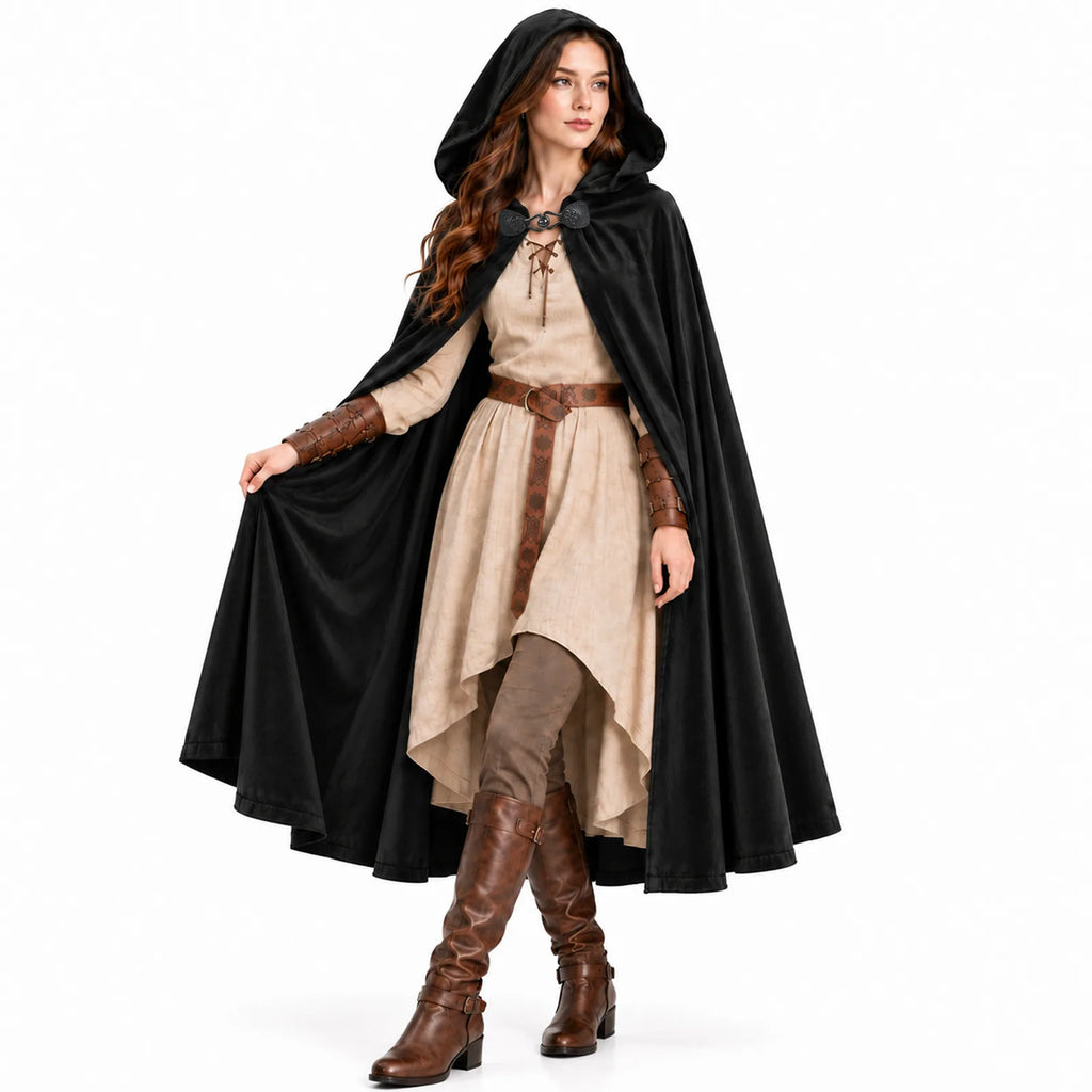 A woman in a black hooded cloak walks forward, lifting one side of the cloak to show its flowing drape.