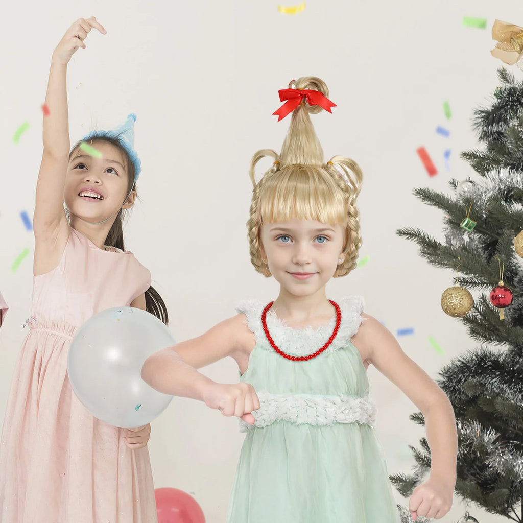 A girl models the blonde braided wig and red necklace near a Christmas tree.