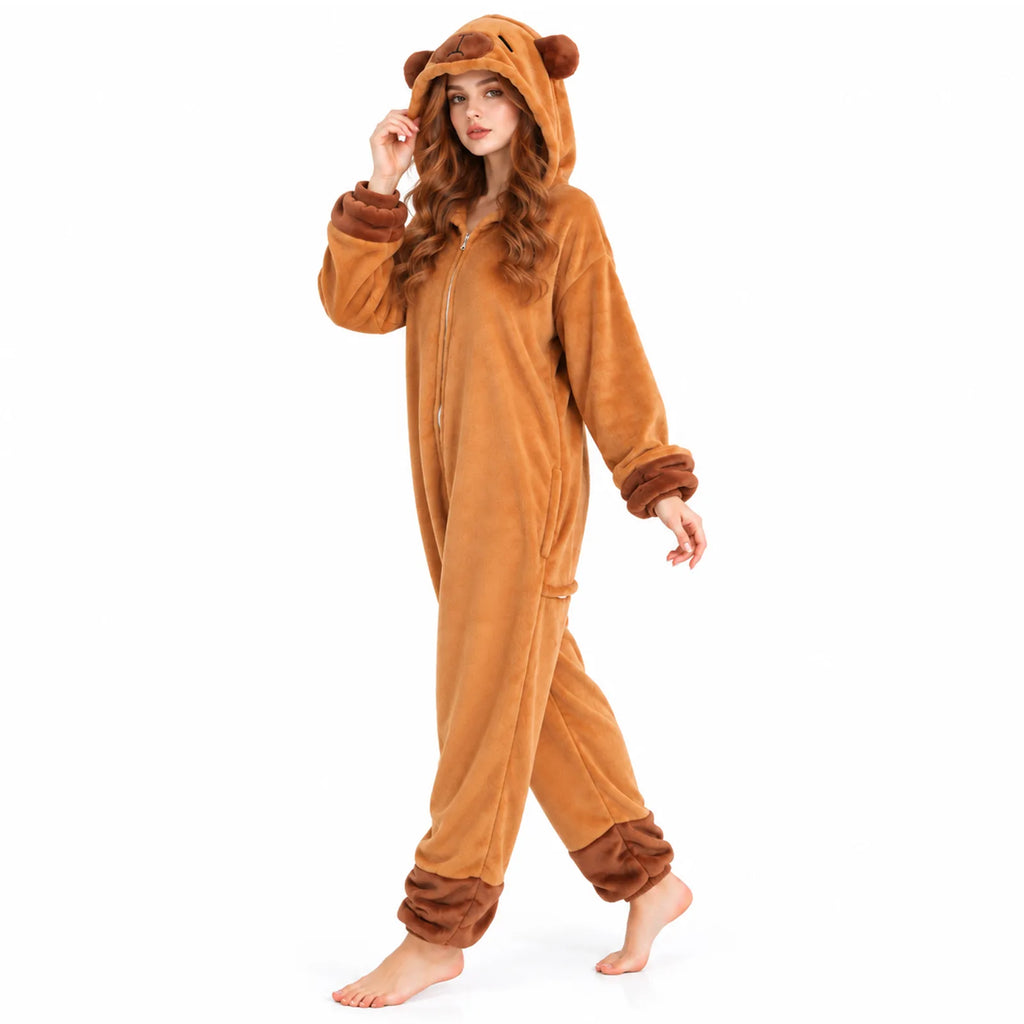A model walks in the brown capybara onesie, showing how the loose flannel fleece drapes and moves with a three-quarter side view.