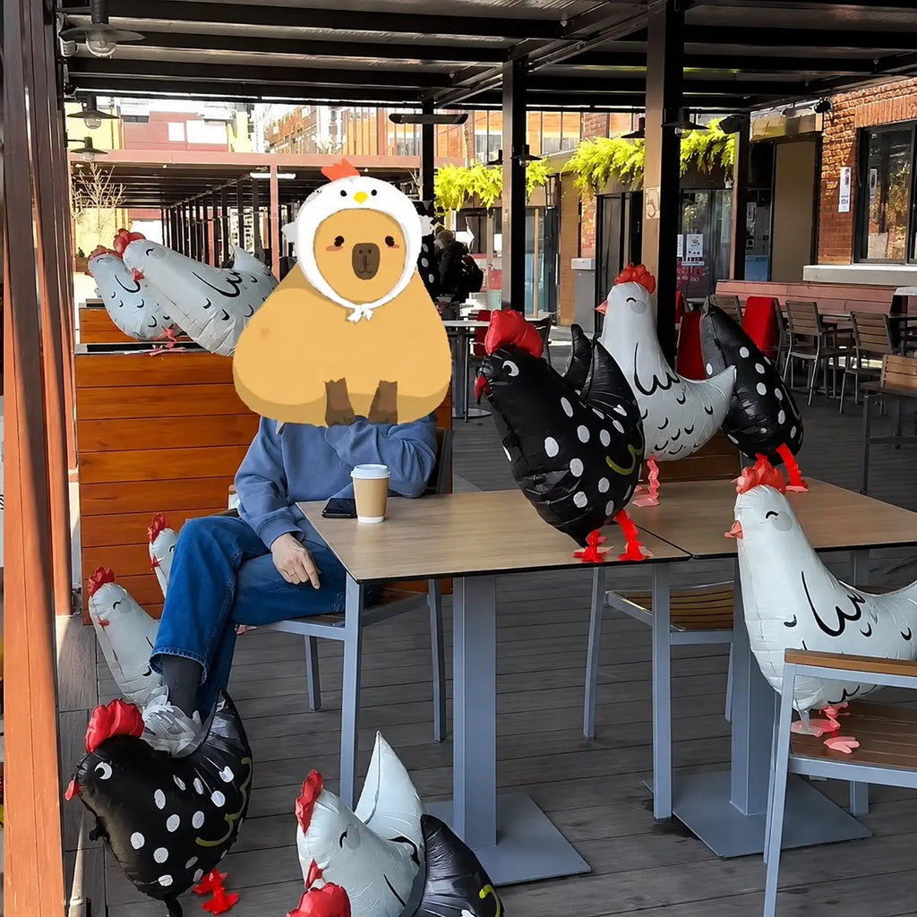 Chicken-shaped foil balloons arranged around an outdoor cafe seating area