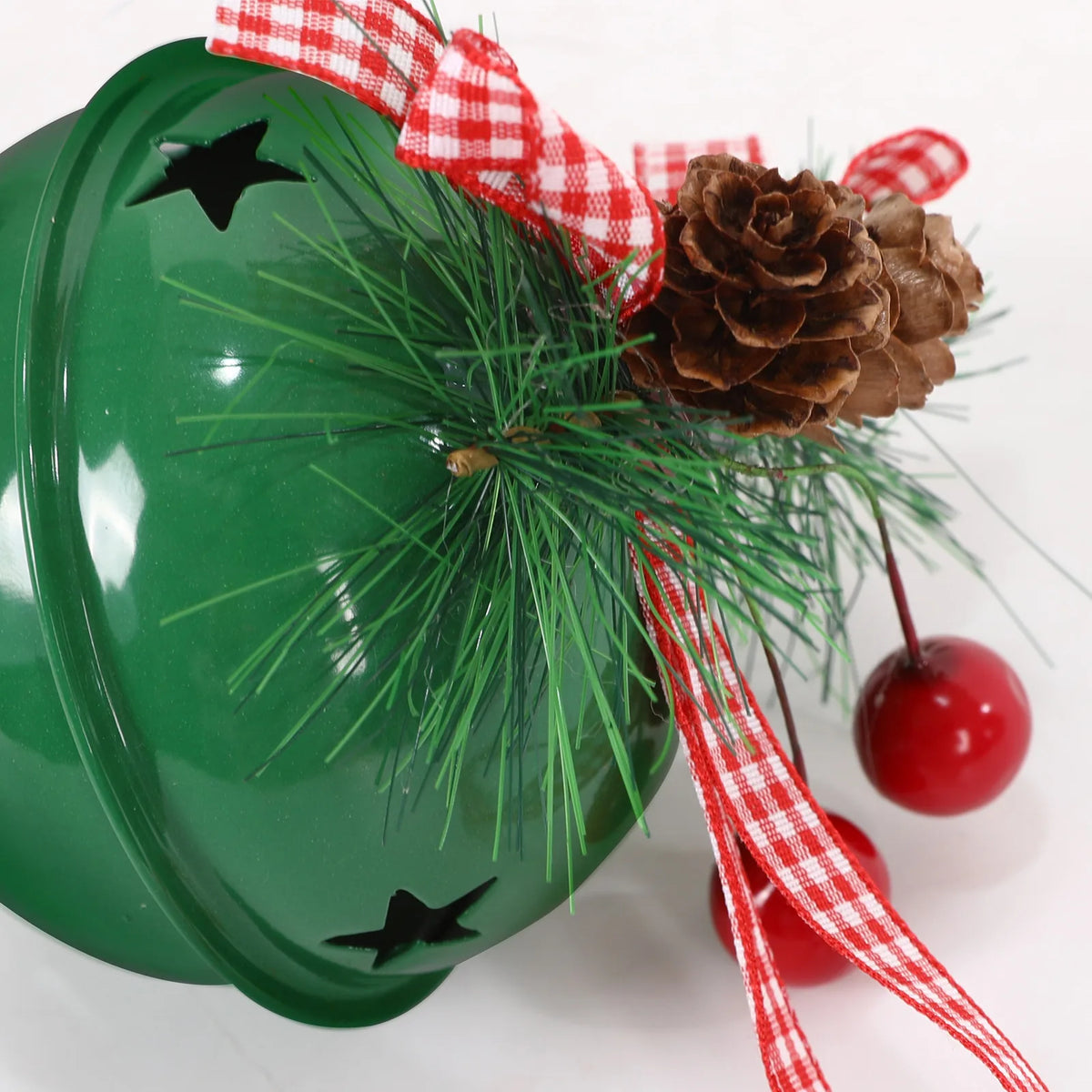 Close-up of the Green metal jingle bell showing the star cutout, pine needles and berry pick