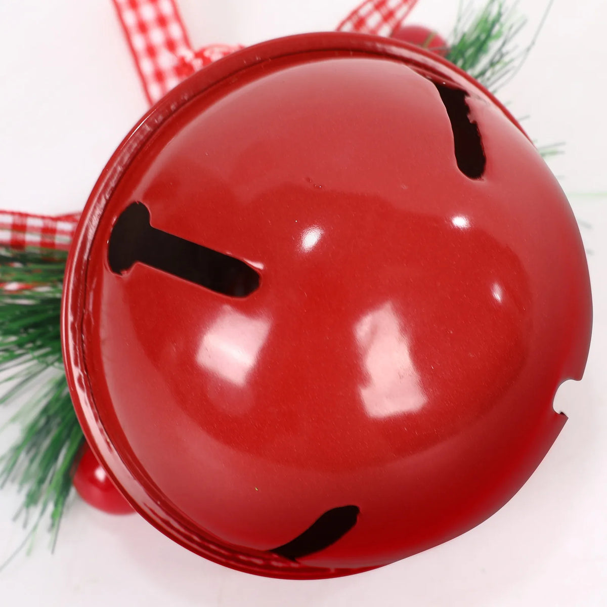 Close-up of the Red metal jingle bell showing the star cutout, pine needles and berry pick