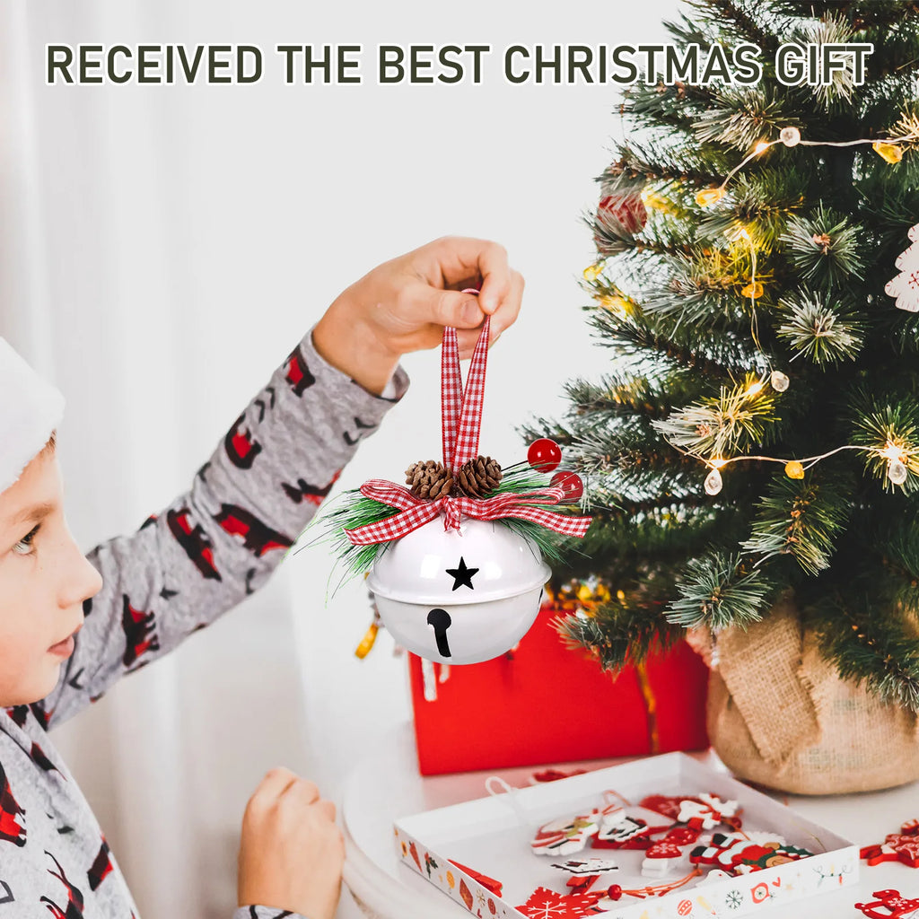 Child hanging the White jingle bell ornament on a Christmas tree beside wrapped gifts