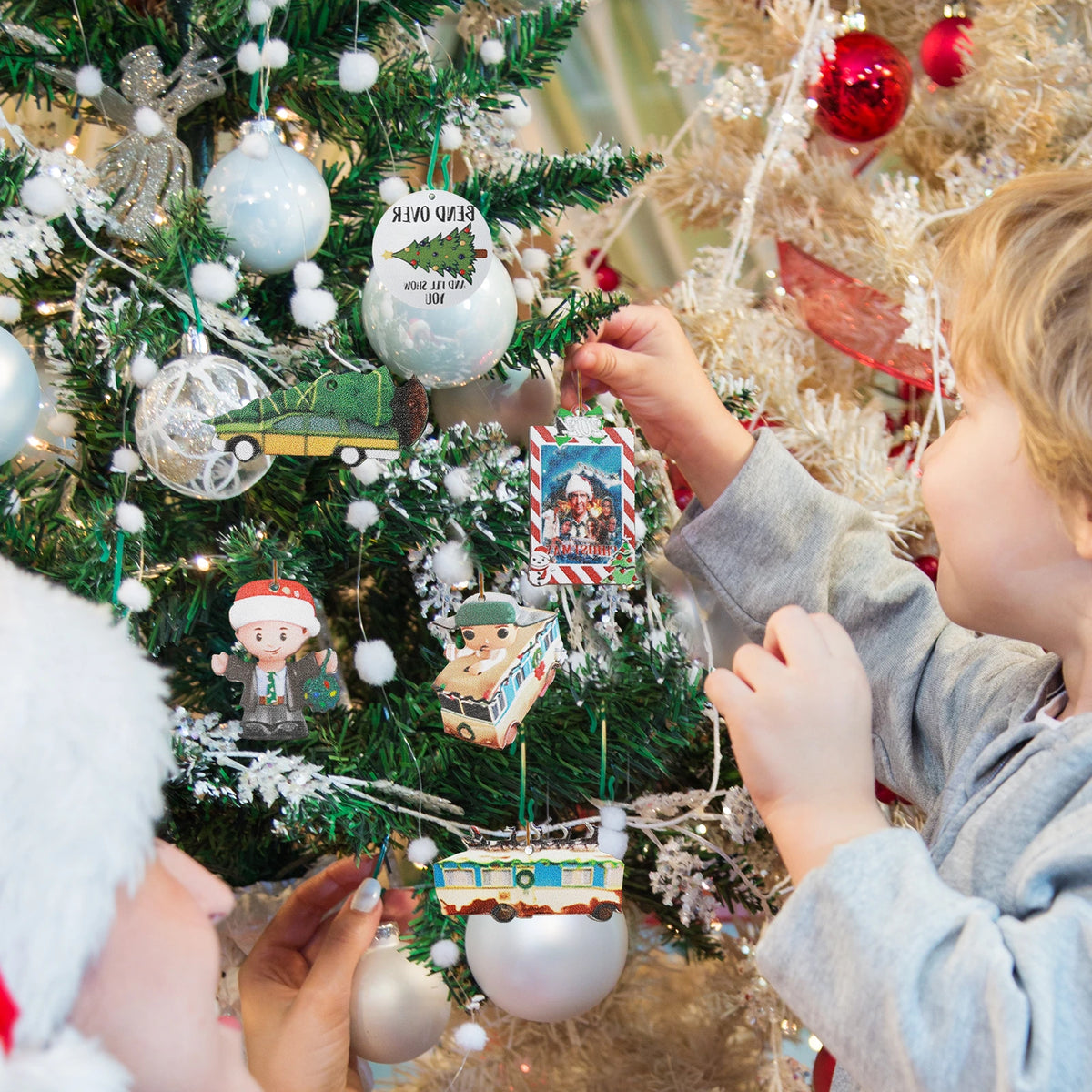 Christmas Vacation inspired vehicle ornaments displayed among Christmas tree branches with other flat printed charms.