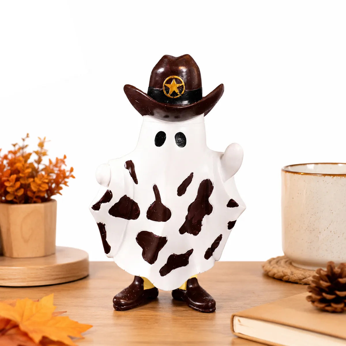 Cowboy ghost figurine displayed on a wooden tabletop with autumn leaves.