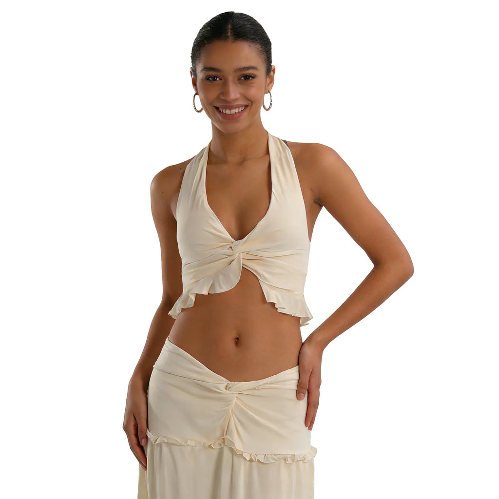A woman models the cream halter top and maxi skirt set in a closer waist-up front pose against a white background.