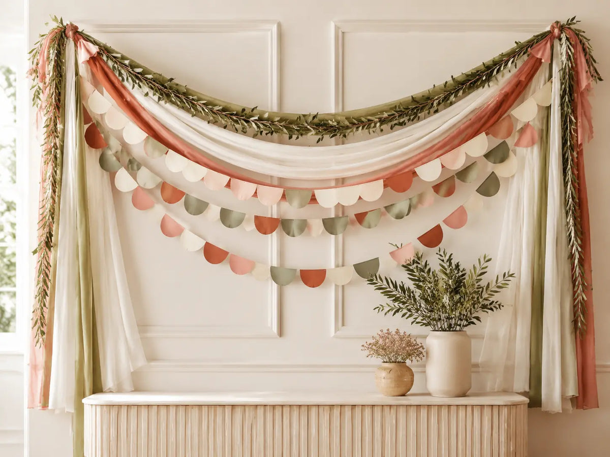 Layered fabric garlands and paper banners decorating an indoor celebration space