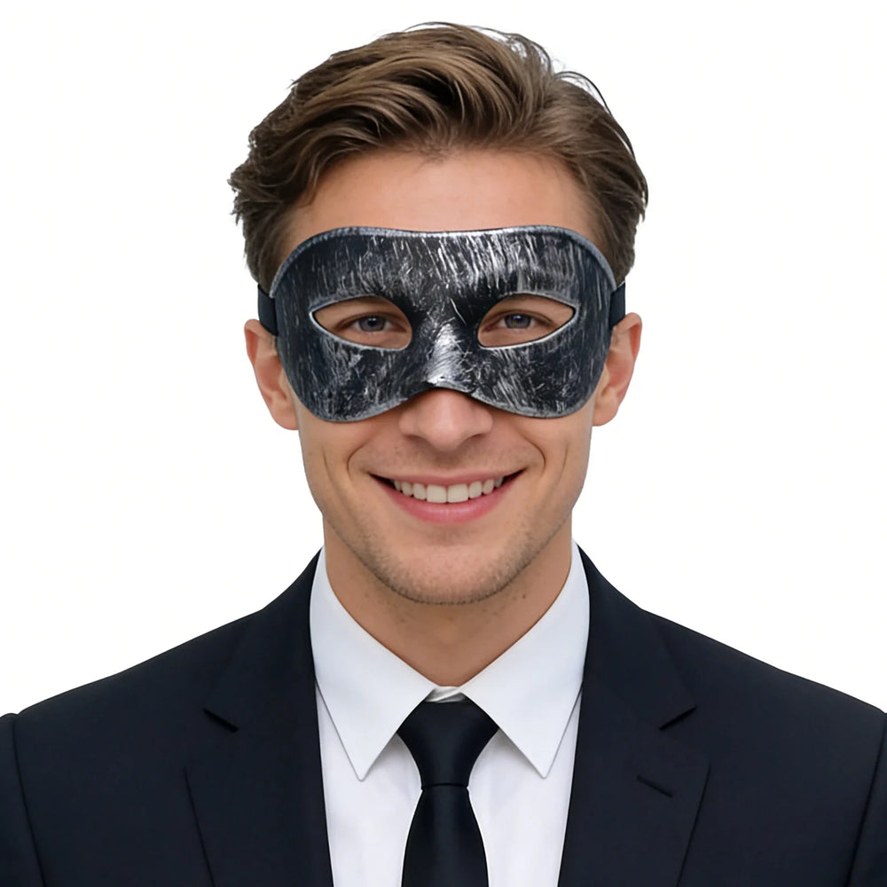 A clear product view presents a vintage black masquerade eye mask with distressed silver finish worn by an adult, with the sculpted eye shape and adjustable black ribbon tie clearly visible.