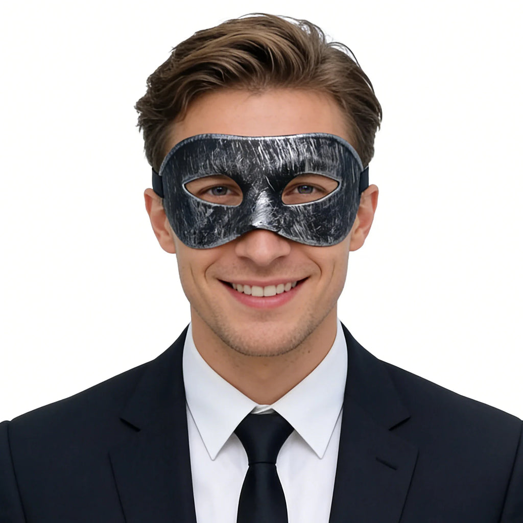 A clear product view presents a vintage black masquerade eye mask with distressed silver finish worn by an adult, with the sculpted eye shape and adjustable black ribbon tie clearly visible.