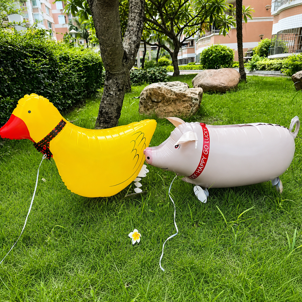 Yellow duck and pink pig walking foil balloons displayed on green grass