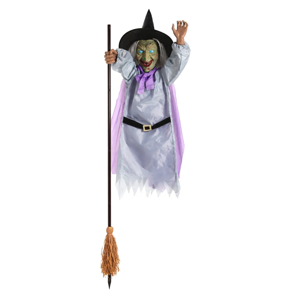 Green-faced flying witch hanging decoration posed on a long broom.
