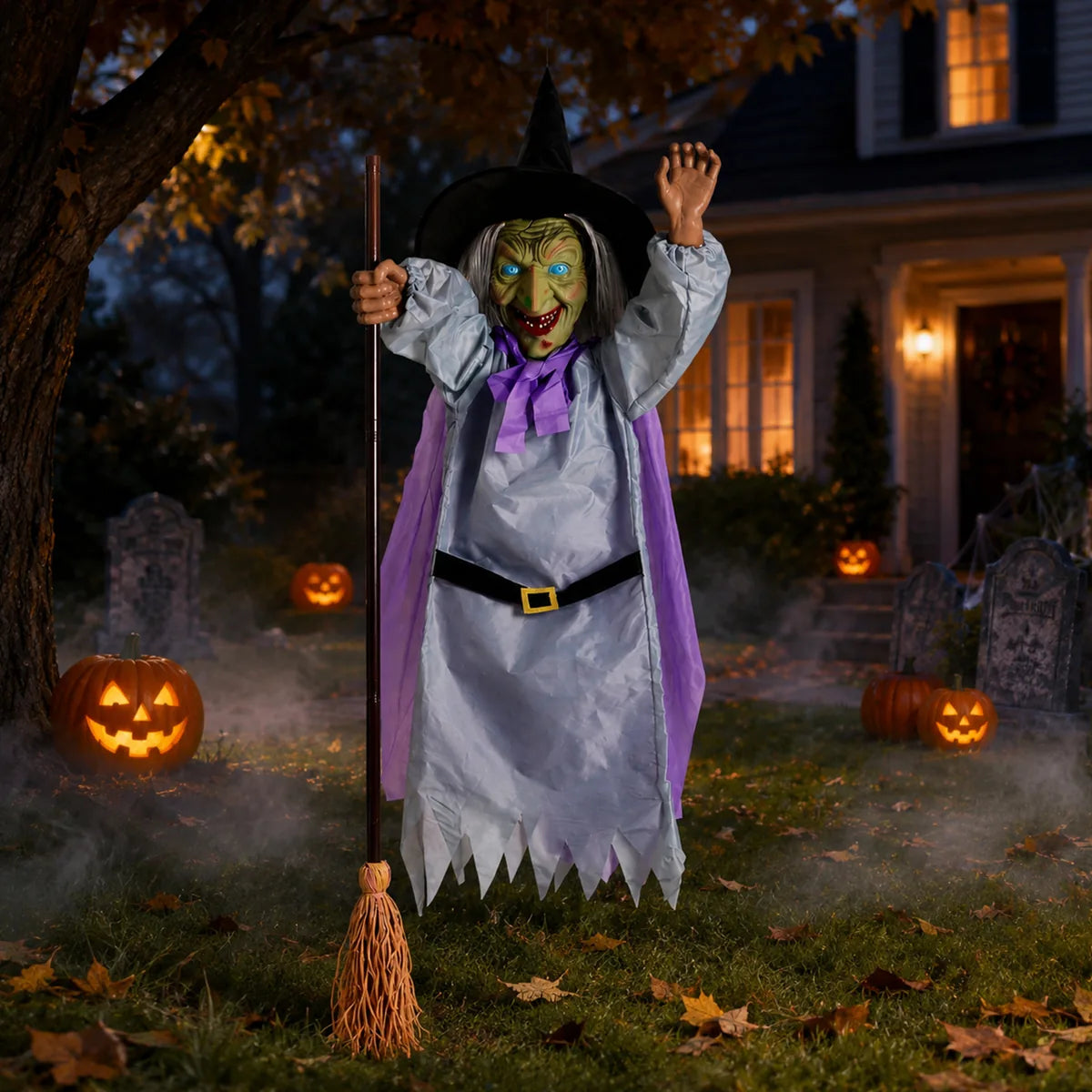 Flying witch on broom displayed in a Halloween yard at night.