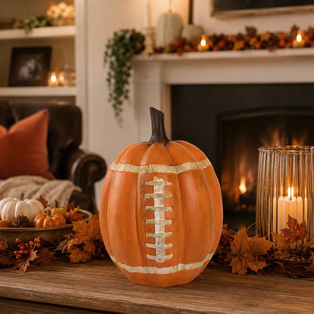 Football pumpkin displayed on a hearth with warm autumn decorations.