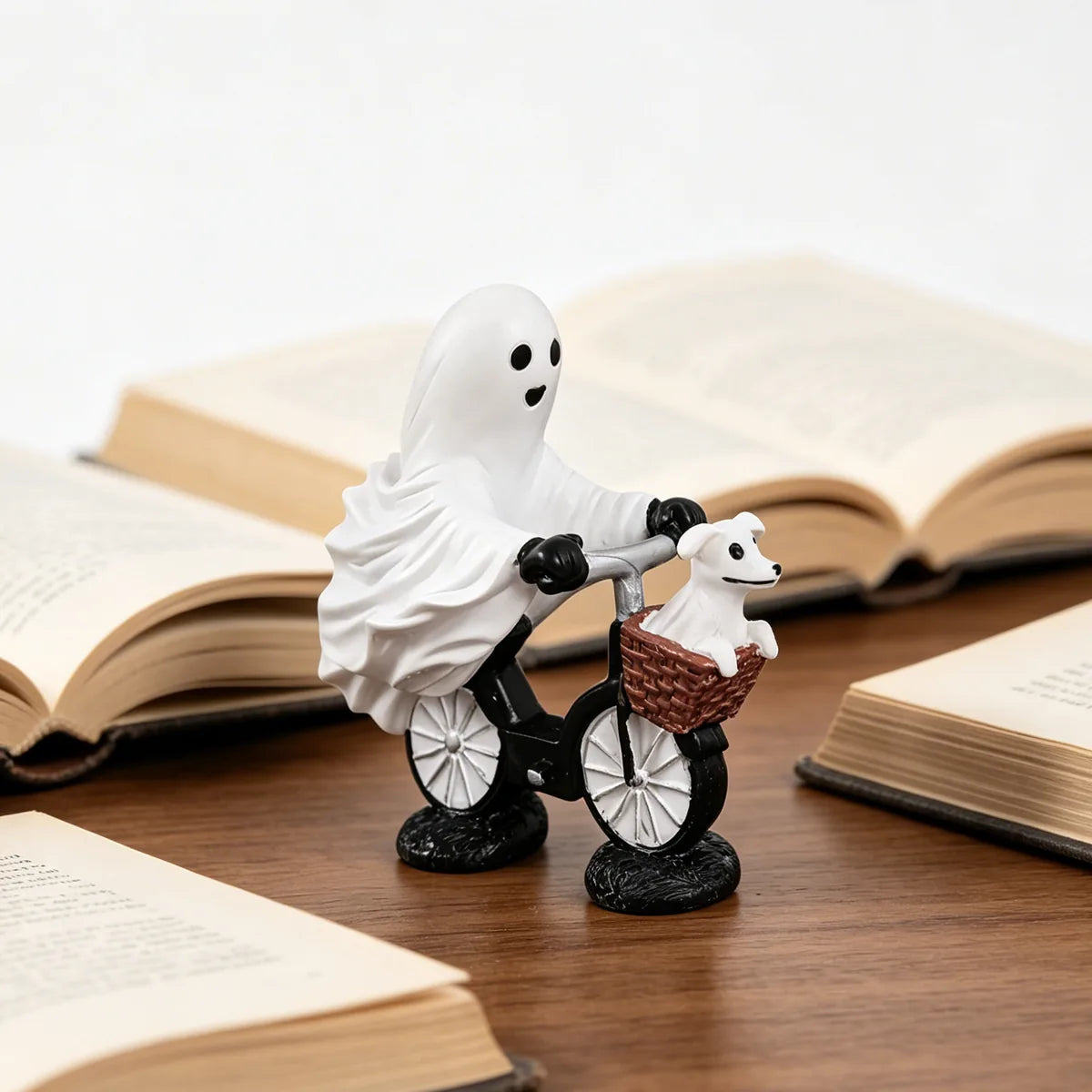 Ghost bicycle dog figurine displayed beside books to show scale.