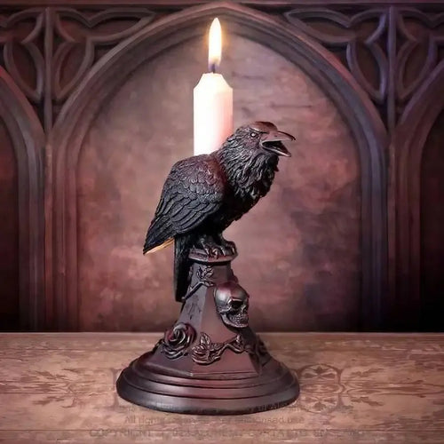 Black gothic raven candle holder with skull and rose details, candle lit, dark moody background