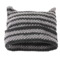 Gray and black striped knit hat with two pointed horn-like corners.