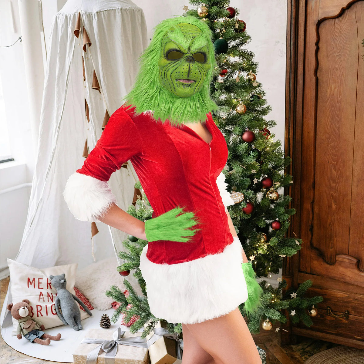 A side pose shows the green mask and gloves beside a tree and wooden wardrobe.