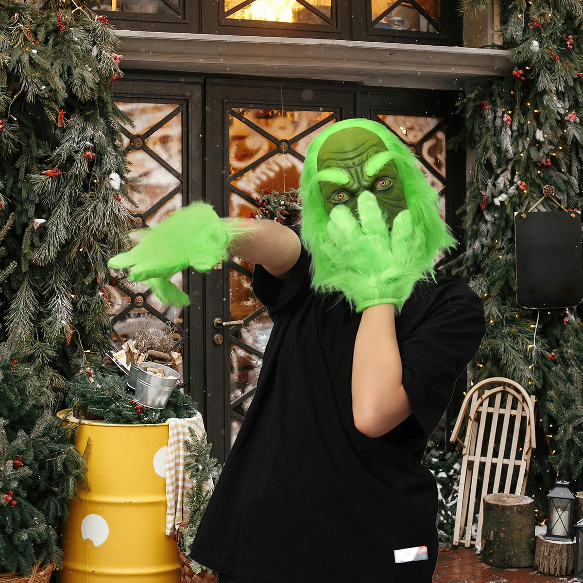 A model wearing the green monster mask reaches toward the camera in a Christmas room. This hatless style has long green hair.