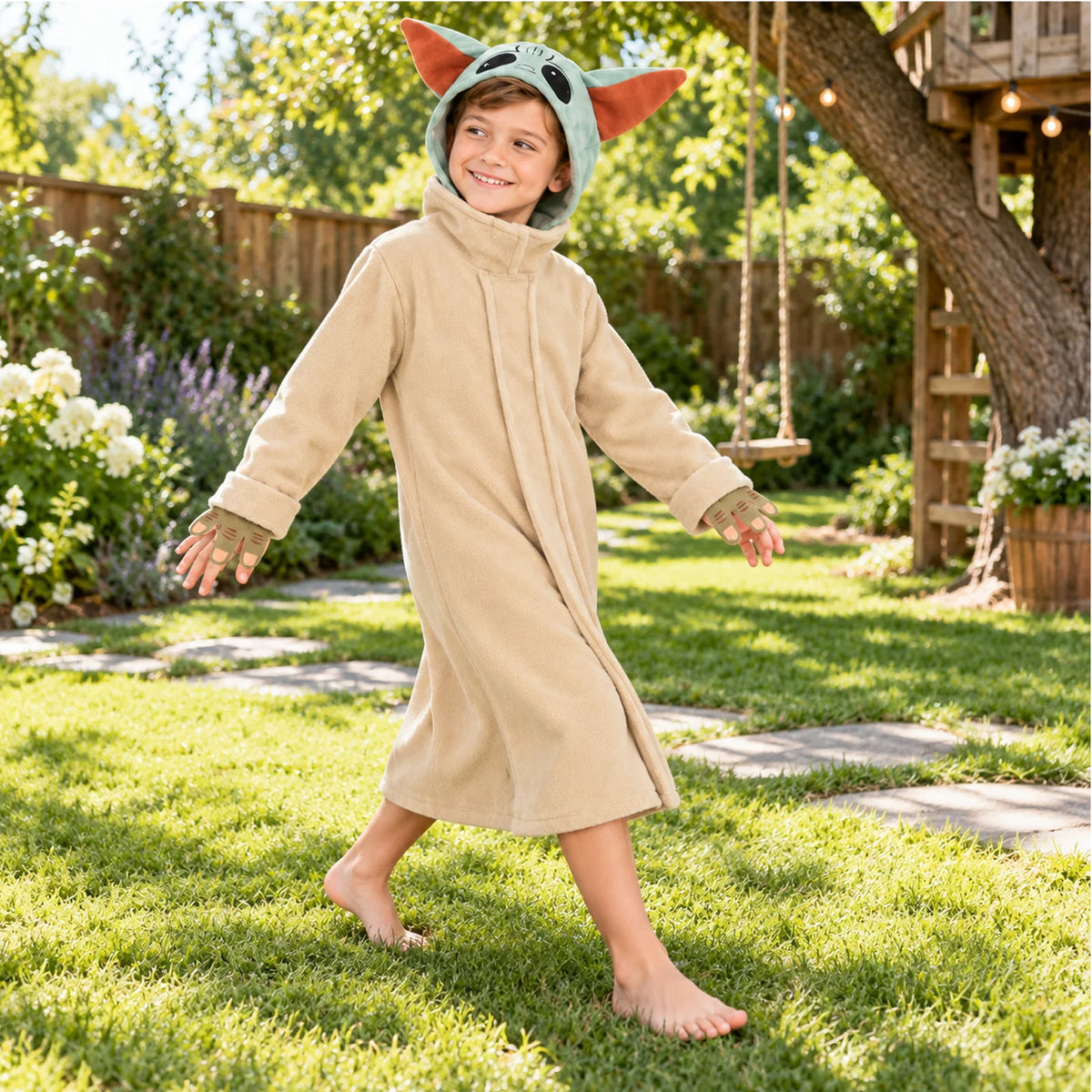 The kids' alien robe costume is shown outdoors as a child walks across the grass near a treehouse.