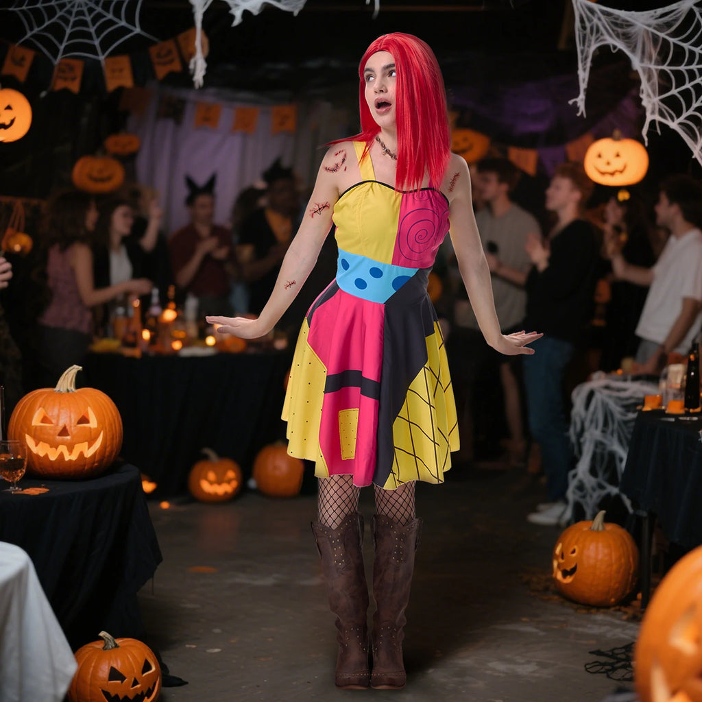 Woman in a multicolor patchwork rag doll costume at a pumpkin-lit Halloween party