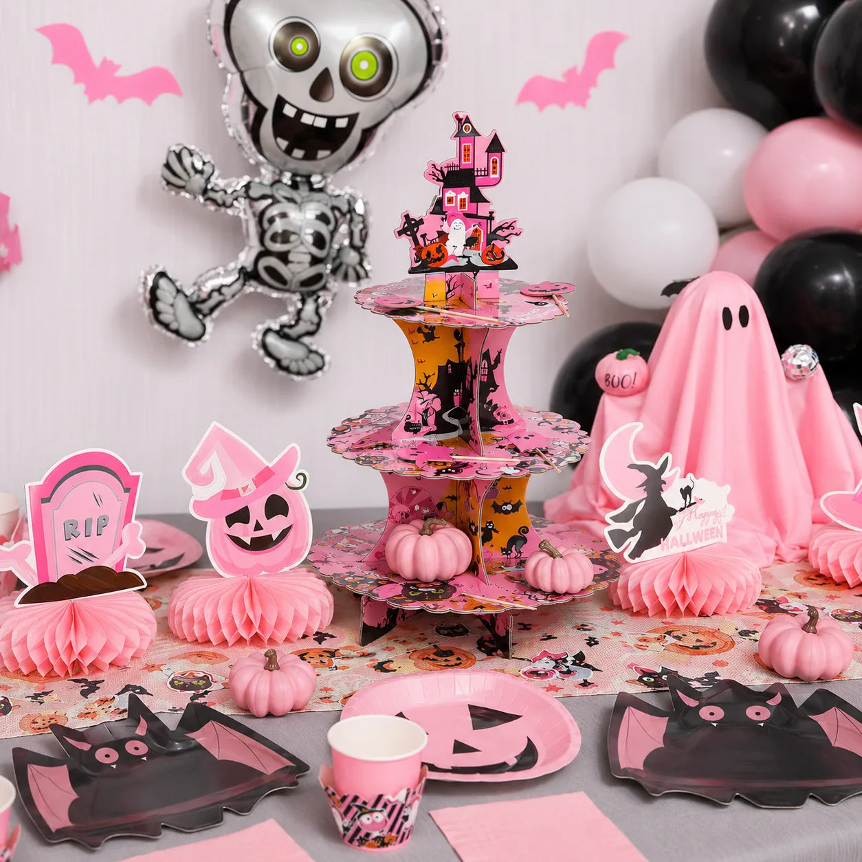 Pink Halloween 3-tier cupcake stand with pumpkin plates, bat plates, mini pumpkins and table decorations