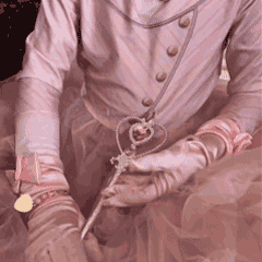 Pink princess costume detail with satin gloves, charm necklace, and magic wand for dress-up play, themed parties, and birthday celebrations.
