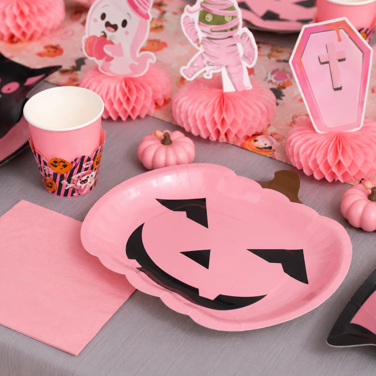 Pink pumpkin paper plate with matching Halloween cup, napkin and table decorations