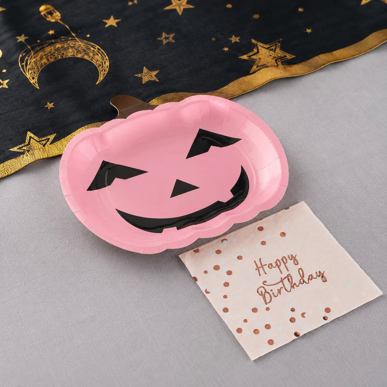 Pink pumpkin plates and Happy Birthday napkins with black gold moon table runner for Halloween birthday party decorations