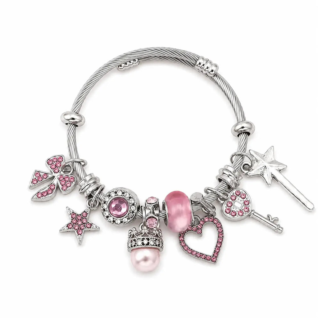 Pink and silver charm bracelet with heart, star, bow, key, wand, crown, pearl, and pink rhinestone charms on a white background.