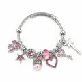Pink and silver charm bracelet with heart, star, bow, key, wand, crown, pearl, and pink rhinestone charms on a white background.