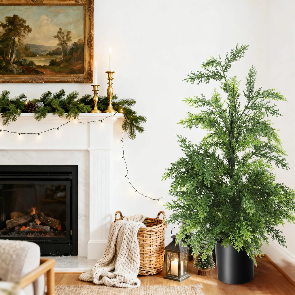The potted tree stands beside a basket and lantern in a fireside setting.