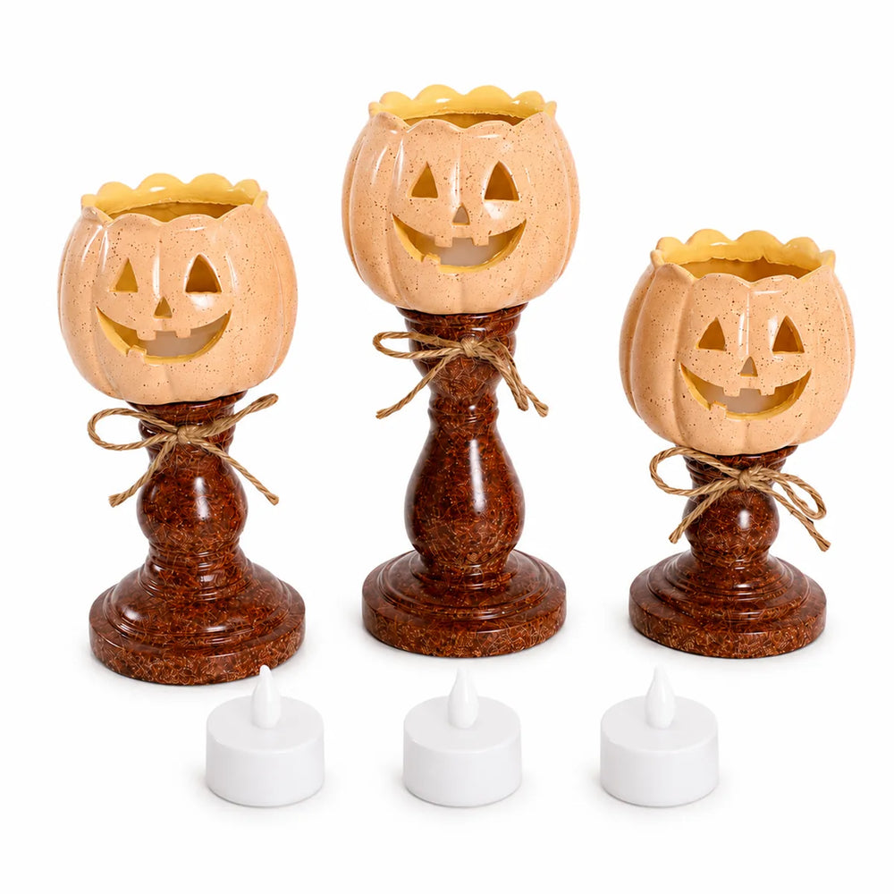 Front view of the pumpkin candle holder set, showing its overall shape and visible design.