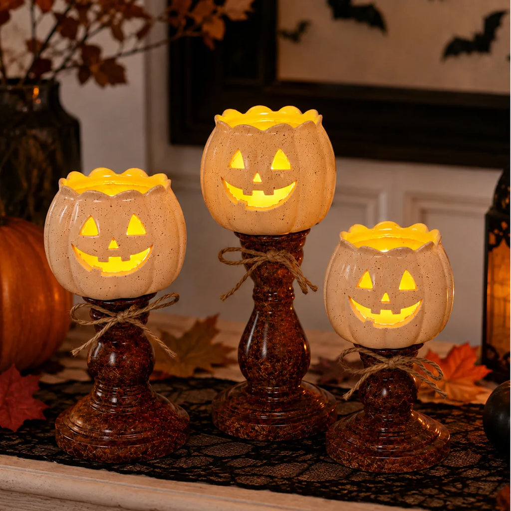 The pumpkin candle holder set displayed in a styled Halloween scene for visual context.