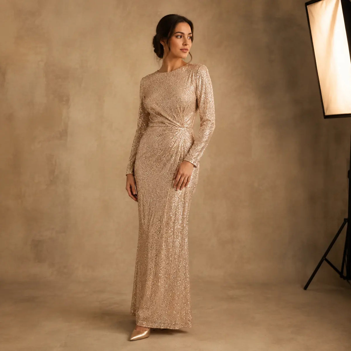 Adult woman in a champagne sequin dress posing in a professional photo studio