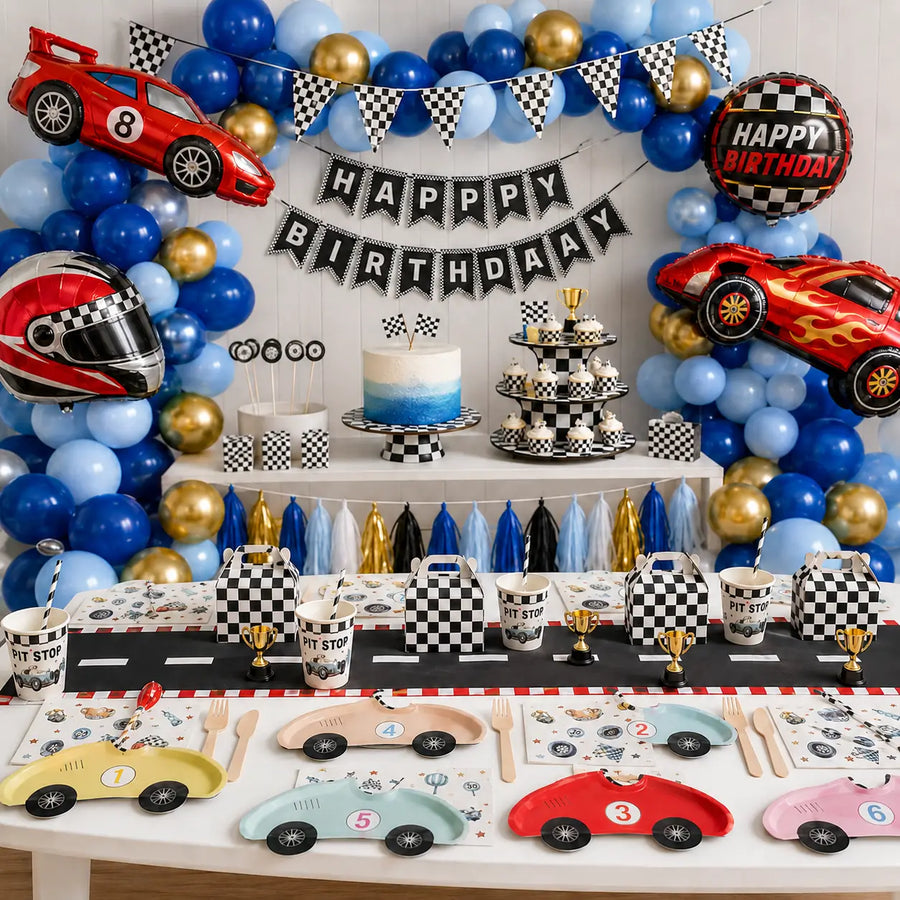 Race car birthday party decorations with a blue and gold balloon garland, checkered gift boxes and car-shaped plates