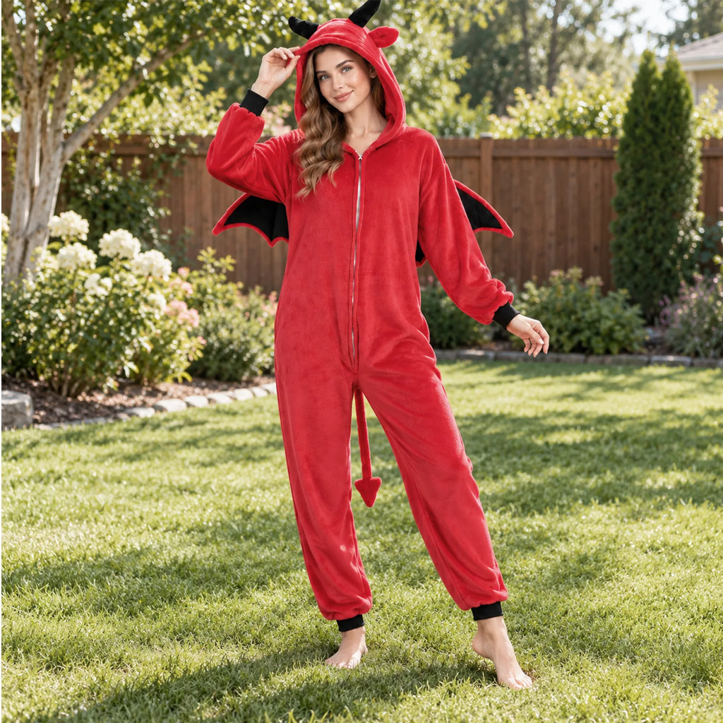 A woman wears the red horned onesie on a garden lawn with its front zipper and tail visible.