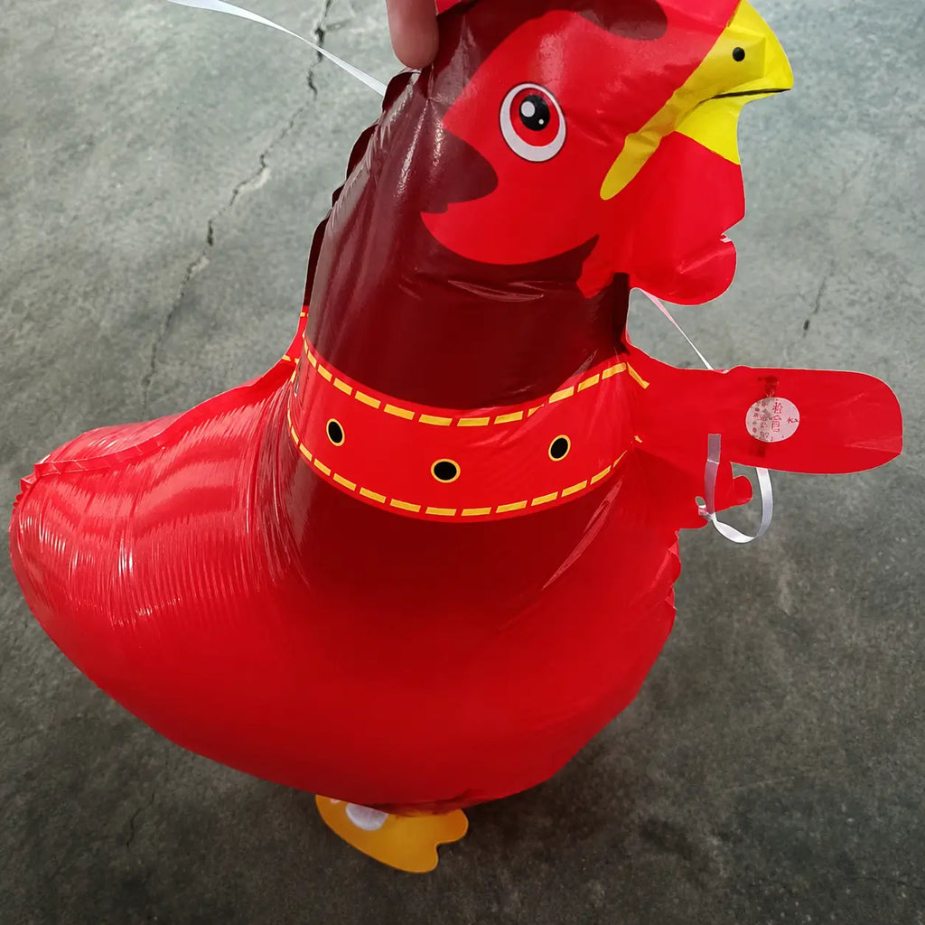 Close-up of a red rooster-shaped foil balloon with yellow beak and glossy finish