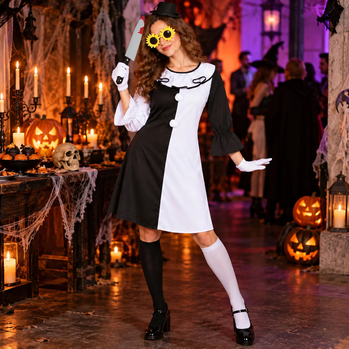 Woman wears the black-and-white scary clown costume in a decorated Halloween party room.