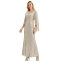 A woman models the silver champagne sequin mermaid gown with cape sleeves from the front against a white background, showing its overall silhouette.