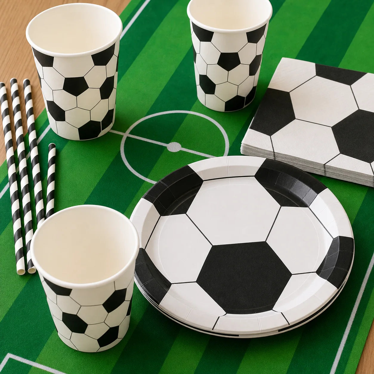Close-up of soccer party plates cups napkins striped straws and green soccer field table runner