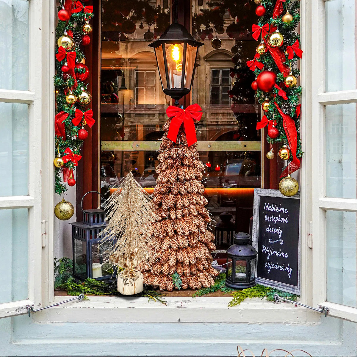 The gold tree is displayed outside a decorated holiday shop window.