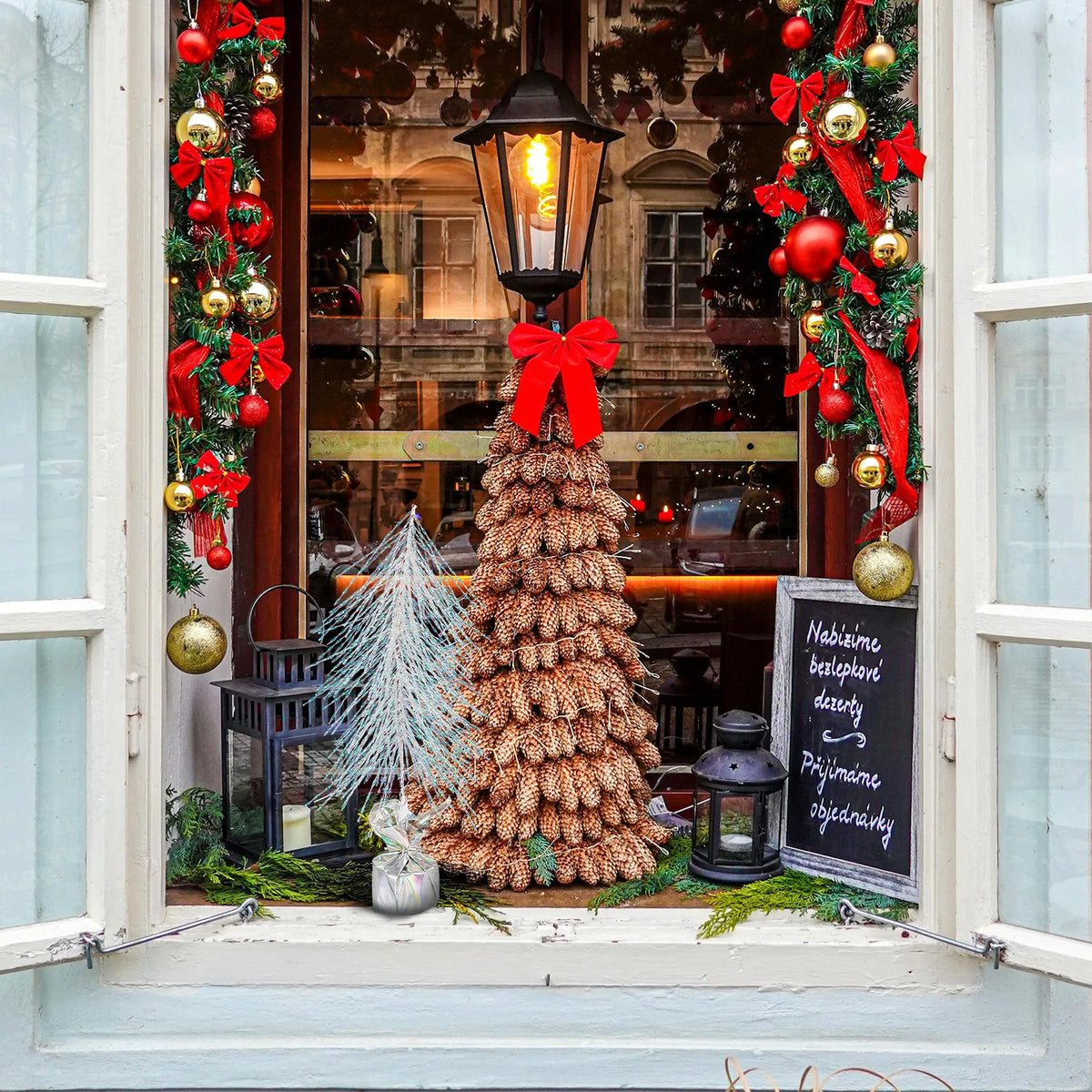 The iridescent tree is displayed outside a decorated holiday shop window.