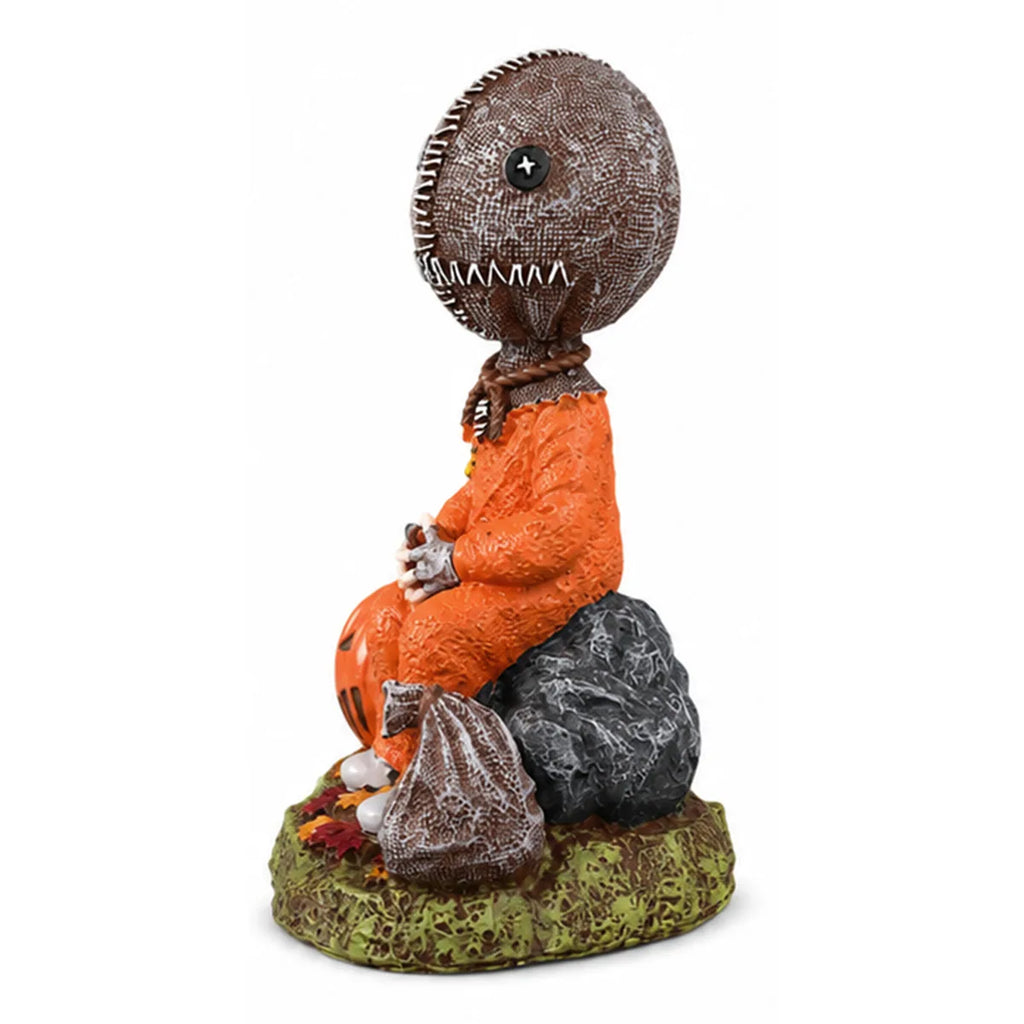 Side view of the trick-or-treat child figurine shows the seated child figure and pumpkin accent.