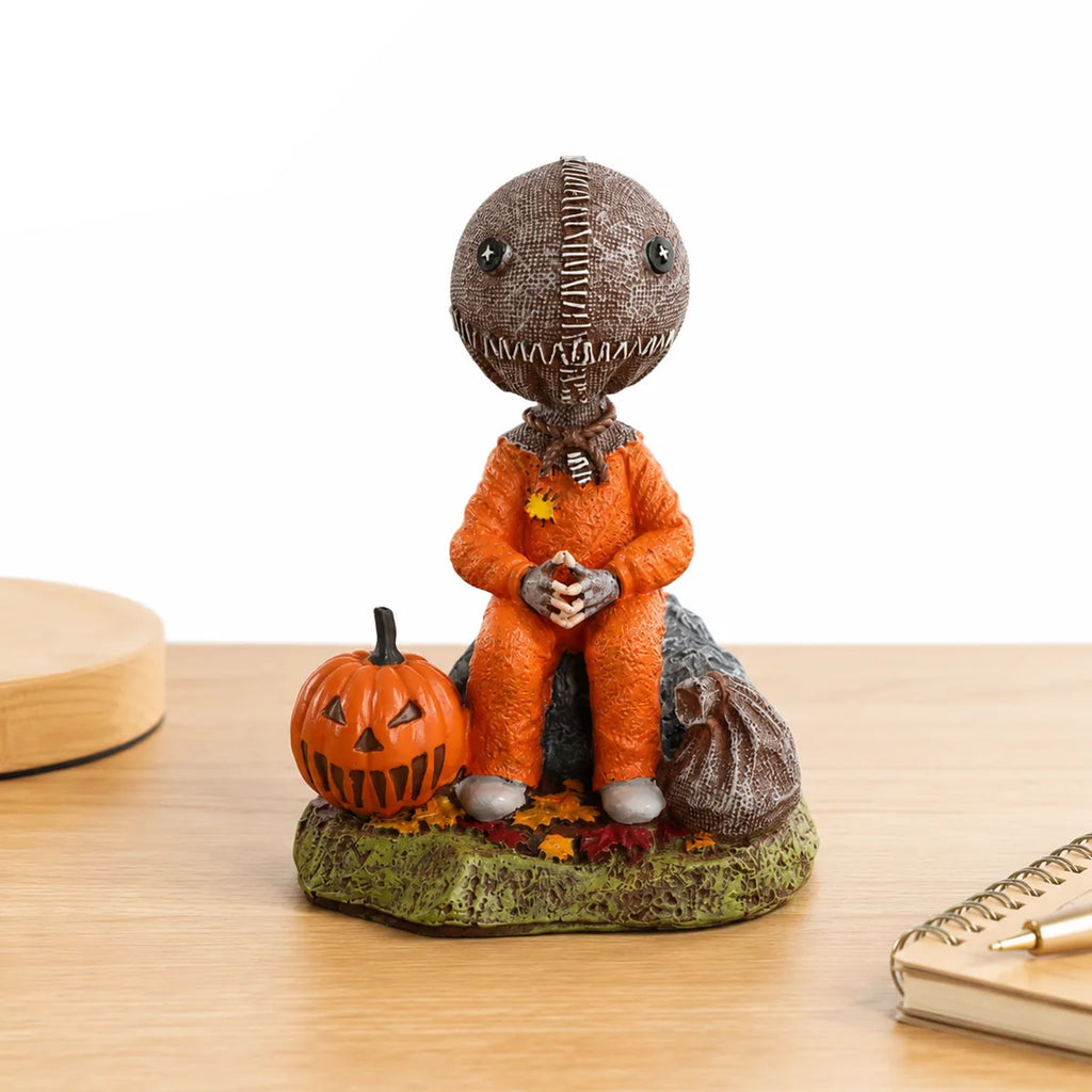 Trick-or-treat child figurine displayed on a wooden tabletop beside a notebook.